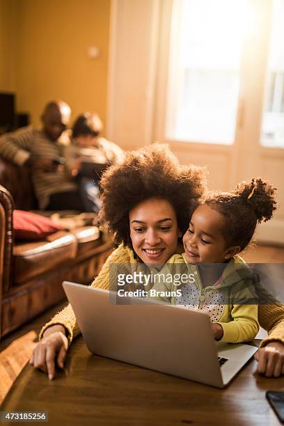 afroamerikanischen mutter und tochter mit laptop zu hause fühlen. - family home internet stock-fotos und bilder