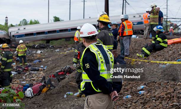 In this handout image supplied by NTSB, NTSB member Robert Sumwalt works on the scene of the Amtrak Train derailment on May 13, 2015 in Philadelphia,...