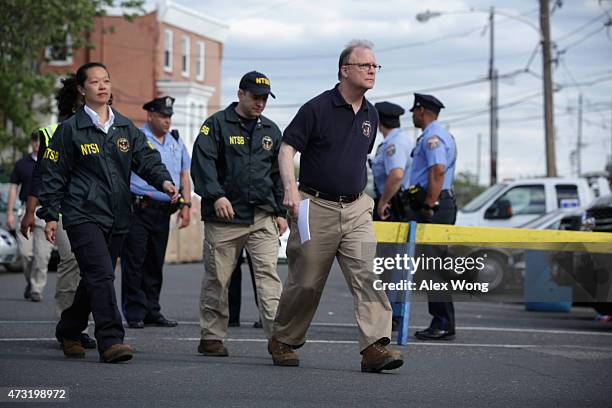 Member Robert Sumwalt walks towards microphones to brief members of the media near the site of a train derailment accident May 13, 2015 in...