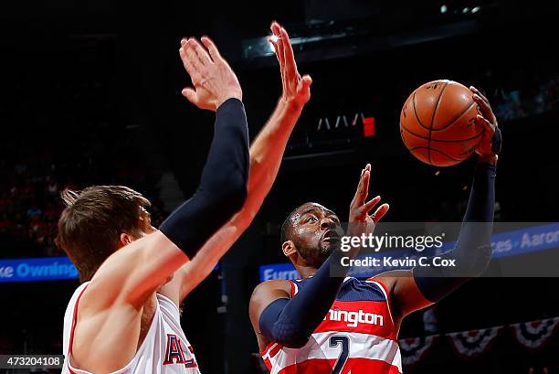 John Wall of the Washington Wizards drives to the basket against Kyle Korver of the Atlanta Hawks during Game Five of the Eastern Conference...