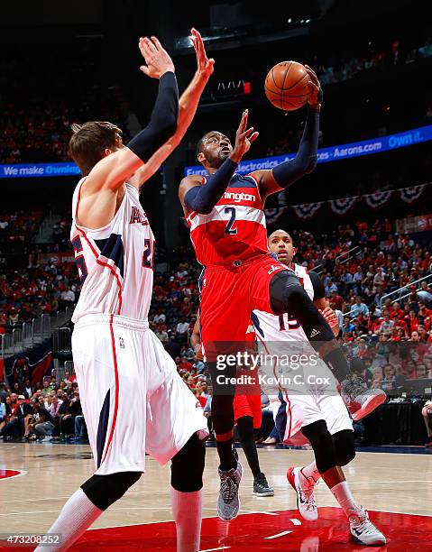 John Wall of the Washington Wizards drives to the basket against Kyle Korver of the Atlanta Hawks during Game Five of the Eastern Conference...