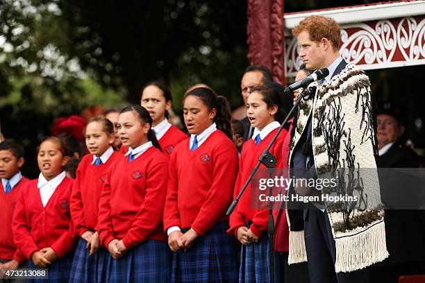 Prince Harry looks on as school children sing a song during a visit to Putiki Marae on May 14, 2015 in Wanganui, New Zealand. Prince Harry is in New...