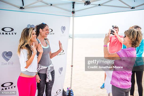 Katrina Hodgson and Karena Dawn pose and sign autographs for partipants after the Tone It Up Beach Workout on May 13, 2015 near the Hermosa Beach...