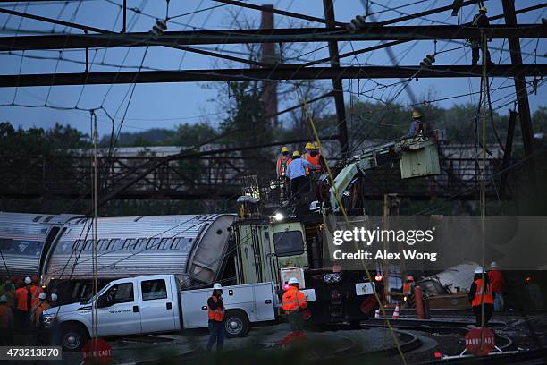 Repair crews inspect damages at the site of a train derailment accident May 13, 2015 in Philadelphia, Pennsylvania. Service has been interrupted...