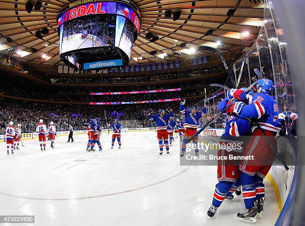 Derek Stepan of the New York Rangers celebrates with his team after scoring the game winning goal in overtime against the Washington Capitals to win...