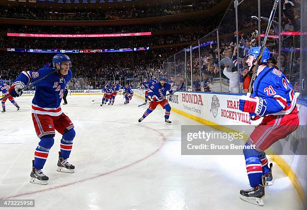 Derek Stepan of the New York Rangers celebrates Jesper Fast and his team after scoring the game winning goal in overtime against the Washington...