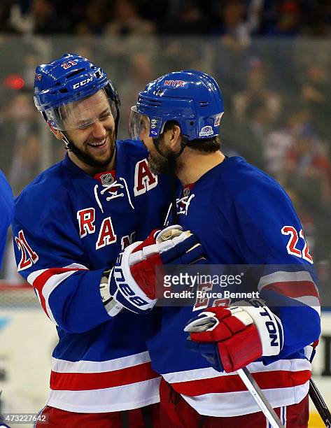 Derek Stepan of the New York Rangers celebrates Dan Boyle after Stepan scored the game winning goal in overtime against the Washington Capitals to...