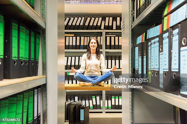 woman meditating in company finance file archive - mlenny photography stockfoto's en -beelden