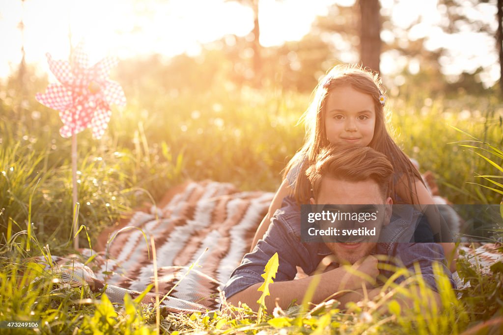 Father and daughter outdoors in a meadow.