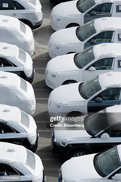 Protective wrapping covers new Audi Q3 automobiles, manufactured by Audi AG, as they stand on the quayside during loading for shipping from the...
