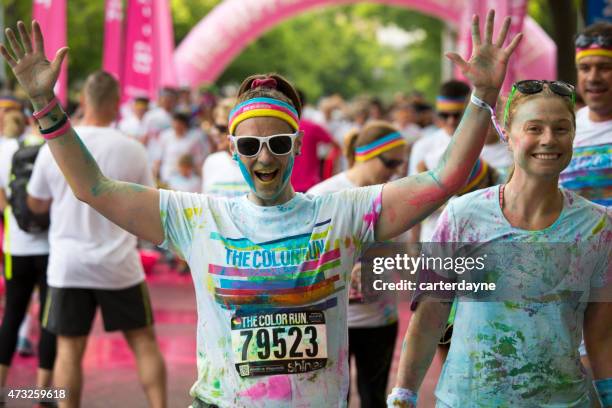 frau mit arme heben feiern, der farbe führen-veranstaltung in seattle - color run stock-fotos und bilder