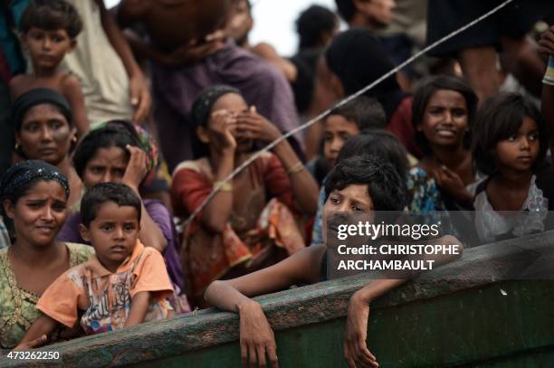 Rohingya migrants stand and sit on a boat drifting in Thai waters off the southern island of Koh Lipe in the Andaman sea on May 14, 2015. The boat...