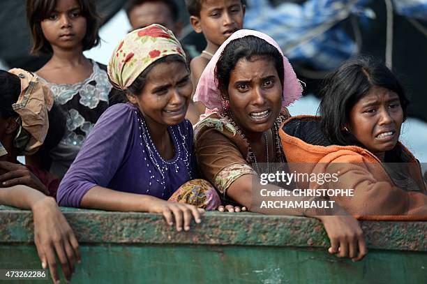 Rohingya migrant women cry as they sit on a boat drifting in Thai waters off the southern island of Koh Lipe in the Andaman sea on May 14, 2015. The...