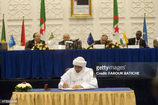 Mali's Secretary-General of the National Movement for the Liberation of Azawad group, Bilal Ag Cherif signs documents during a signing ceremony for a...
