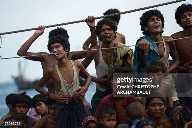 Rohingya migrants stand and sit on a boat drifting in Thai waters off the southern island of Koh Lipe in the Andaman sea on May 14, 2015. The boat...