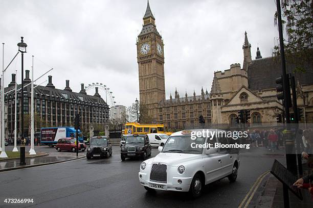 London taxi cabs pass Elizabeth Tower, home to Big Ben, as it stands above the Houses of Parliament in London, U.K., on Thursday, May 14, 2015. Data...