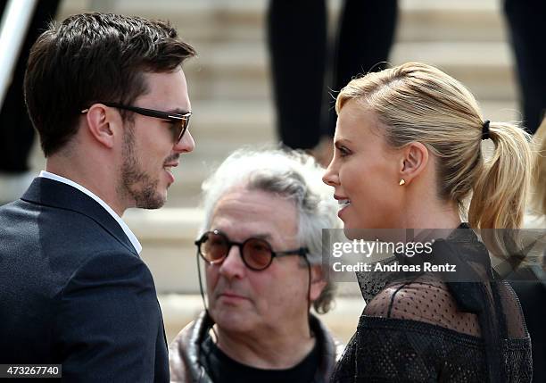 Charlize Theron and Nicholas Hoult greet each other during a photocall for "Mad Max: Fury Road" during the 68th annual Cannes Film Festival on May...