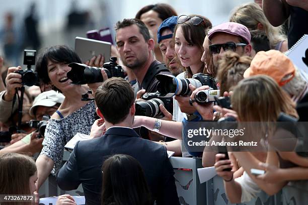 Nicholas Hoult greets fans as he attends a photocall for "Mad Max: Fury Road" during the 68th annual Cannes Film Festival on May 14, 2015 in Cannes,...