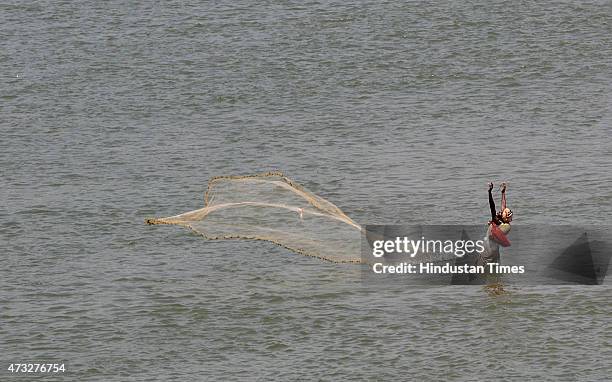 An Indian fisherman spreading his net to catch fishes in River Tawi on May 14, 2015 in Jammu, India.