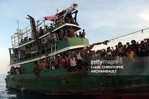 Rohingya migrants sit and stand on a boat drifting in Thai waters off the southern island of Koh Lipe in the Andaman sea on May 14, 2015. A boat...