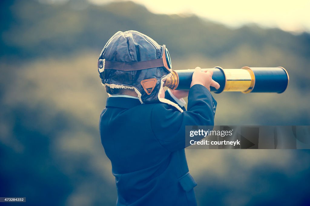Young boy in a business suit with telescope.