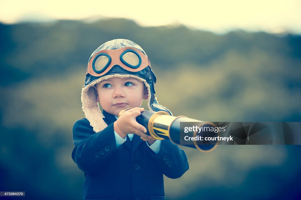 Young boy in a business suit with telescope.