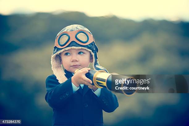 young boy in a business suit with telescope. - flying goggles stock pictures, royalty-free photos & images