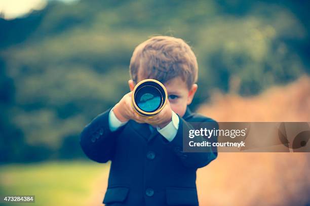 young boy in a business suit with telescope. - day telescope stock pictures, royalty-free photos & images