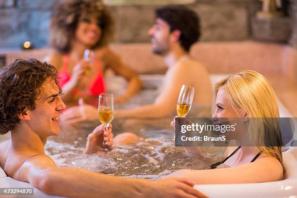 young happy friends enjoying in champagne at hot tub and communicating. - hot tub party stock pictures, royalty-free photos & images