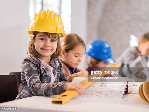 little girl architect smiling and looking at camera. - boy in hard hat stock pictures, royalty-free photos & images