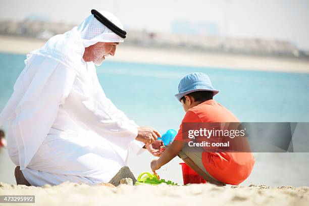 grandfather and grandson enjoying their leisure time - saudi arabia beach stock pictures, royalty-free photos & images