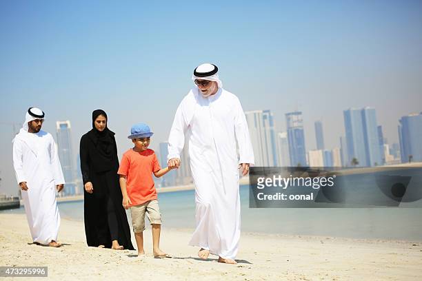 arab family enjoying their leisure time on beach - qatari family stockfoto's en -beelden