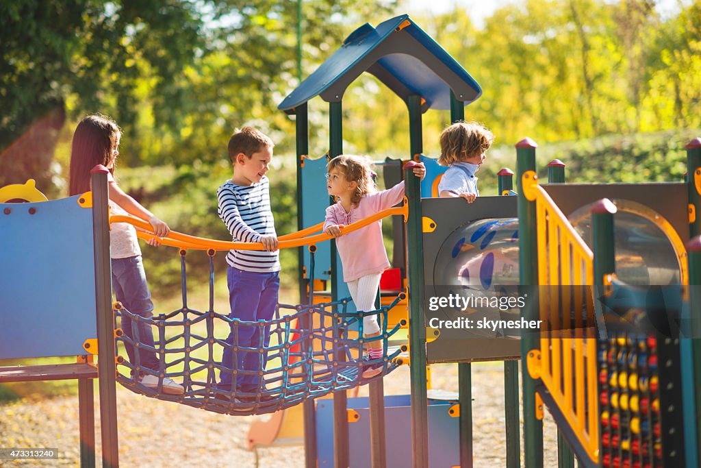 Children playing in the park at playground and communicating.