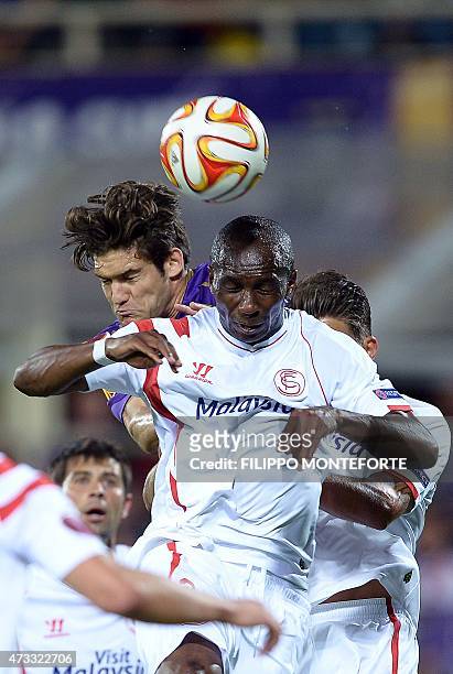 Fiorentina's Spanish defender Marcos Alonso Mendoza vies for the ball with Sevilla's Cameroonian midfielder Stephane M'Bia during the UEFA Europa...