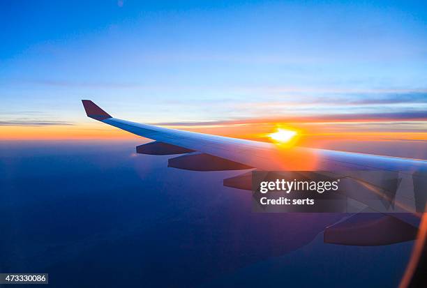 seeing the sunset on flight - wing stock pictures, royalty-free photos & images