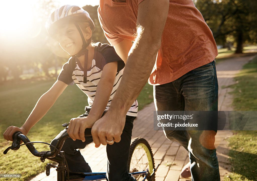 Testing out his new wheels at the park with dad