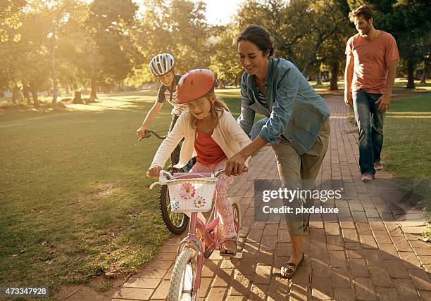 the love coming to the park - family riding bikes with helmets stock pictures, royalty-free photos & images