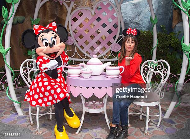 In this handout photo provided by Disney Parks, actress Lea Michele dons Minnie ears on a visit to Minnie Mouse's house in Mickey's Toontown May 14,...