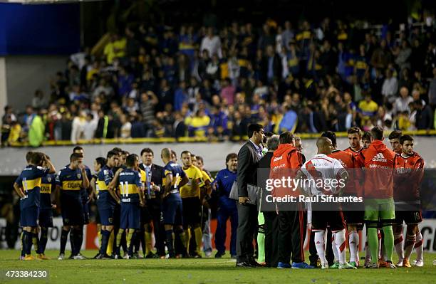 Players of River Plate and Boca Juniors talk while the match has been delayed due to a tear gas bomb thrown by fans of Boca Juniors during a second...