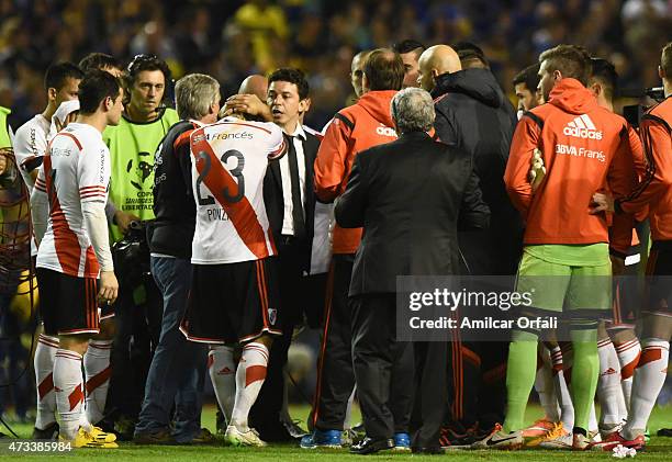 Leonardo Ponzio of River Plate reacts after receiving tear gas as his team was entering onto the field during a second leg match between Boca Juniors...