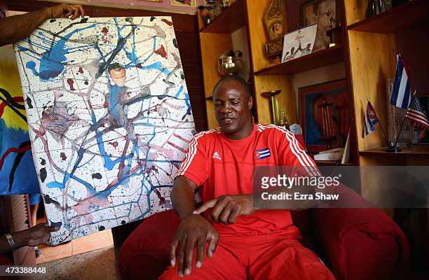Picture of Flix Savn with his paintings titled "Decision" at his home on May 10, 2015 in Havana, Cuba. After Savn retired from boxing, he took up...