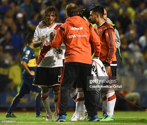 Leonardo Ponzio of River Plate gestures after receiving tear gas from Boca Junior's fans during a second leg match between Boca Juniors and River...