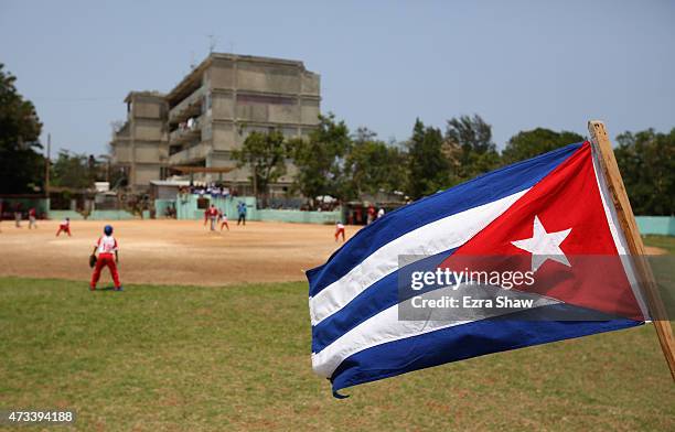 The Cuban flag flies in the outfield as kids play baseball on May 09, 2015 in the Alamar subarb of Havana, Cuba.