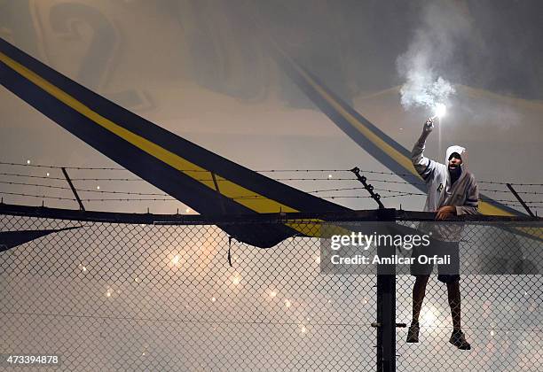 Fan of Boca Juniors holds a flare during a second leg match between Boca Juniors and River Plate as part of round of sixteen of Copa Bridgestone...