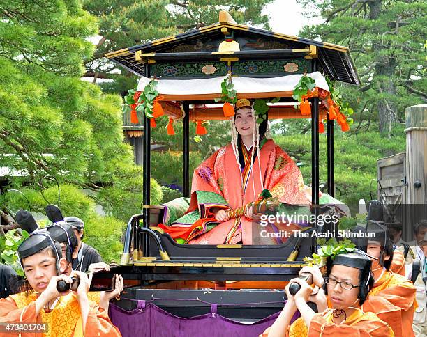 An "Oyoyo" float carrying the "Saio-dai" queen wearing "junihitoe," the layered formal kimono of Heian Period court ladies march on during the Aoi...