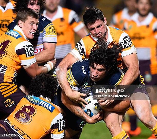 James Tamou of the Cowboys is tackled by Sam Thaiday and Matthew Gillett of the Broncos during the round 10 NRL match between the North Queensland...