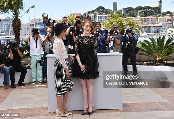 Actresses Parker Posey and Emma Stone hold their skirts down during a photocall for the film "Irrational Man" at the 68th Cannes Film Festival in...