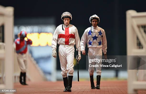 Craig Newitt and Michael Rodd head out onto the track during Singapore racing at Kranji Racecourse on May 15, 2015 in Singapore.