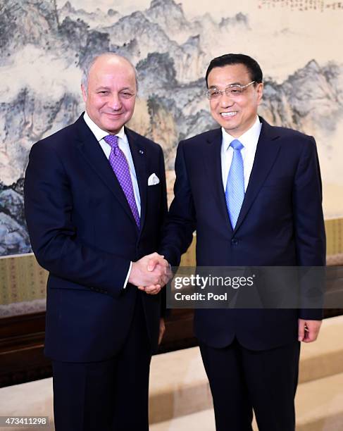Chinese Premier Li Keqiang shakes hands with French Foreign Minister Laurent Fabius during a meeting at the Zhongnanhai leadership compound on May...