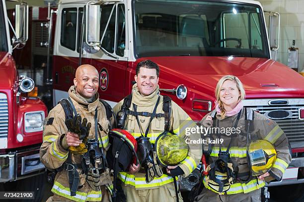 diverse group of fire fighters at the station - brand name stockfoto's en -beelden